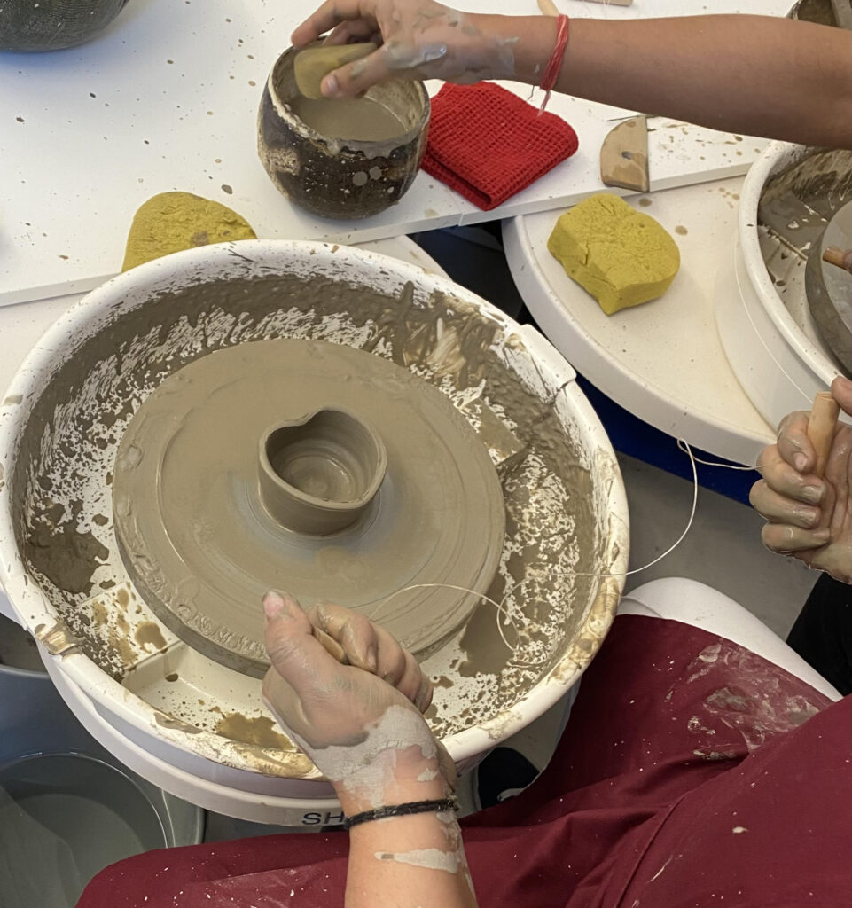 Couple enjoying private pottery class in Hackney London learning wheel throwing together